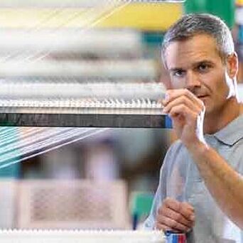 Trabajador ajustando máquina textil
