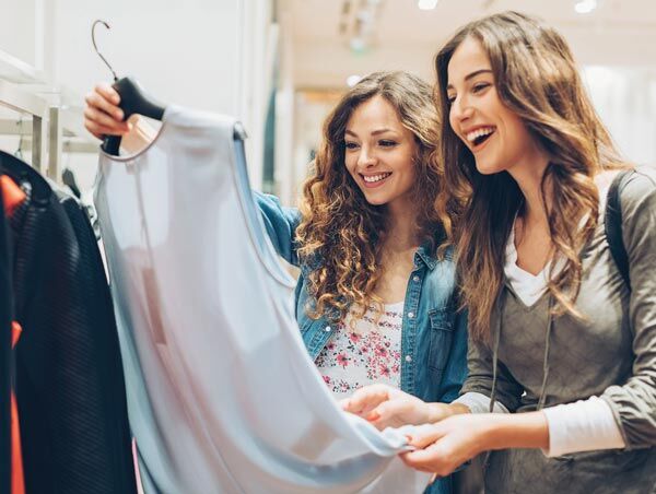 Consumidores que compran moda sostenible Dos mujeres mirando una camiseta en una tienda minorista