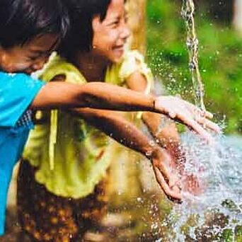 Dos niños chapoteando en agua limpia
