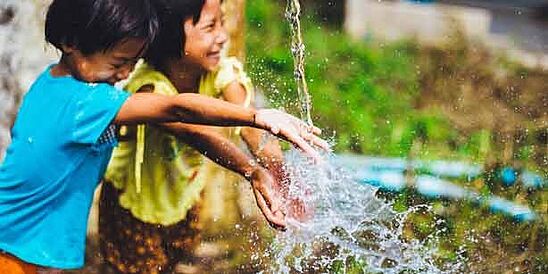 Dos niños chapoteando en agua limpia