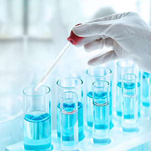 Tubos de ensayo con solución de extracción azul en una gradilla de laboratorio.