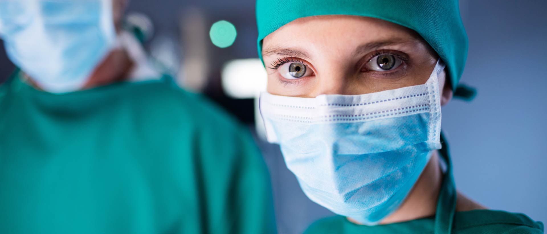 Médicos con batas quirúrgicas, mascarillas y cobertores para la cabeza