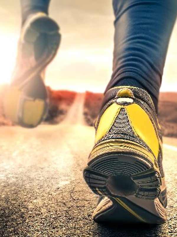 Calzado probado y certificado Vista desde el suelo en una persona que se aleja con zapatos deportivos amarillos