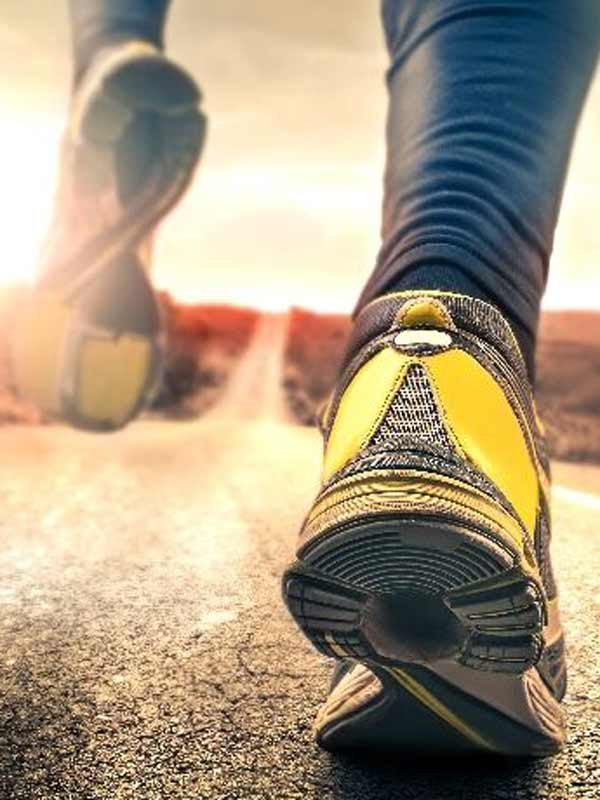 Vista desde el suelo en una persona que se aleja con zapatos deportivos amarillos