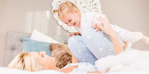 Mamá y niño en pijama en la cama